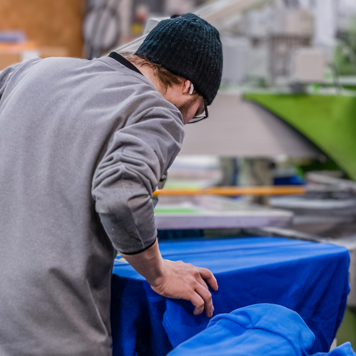 Person inspecting blue fabric carefully.