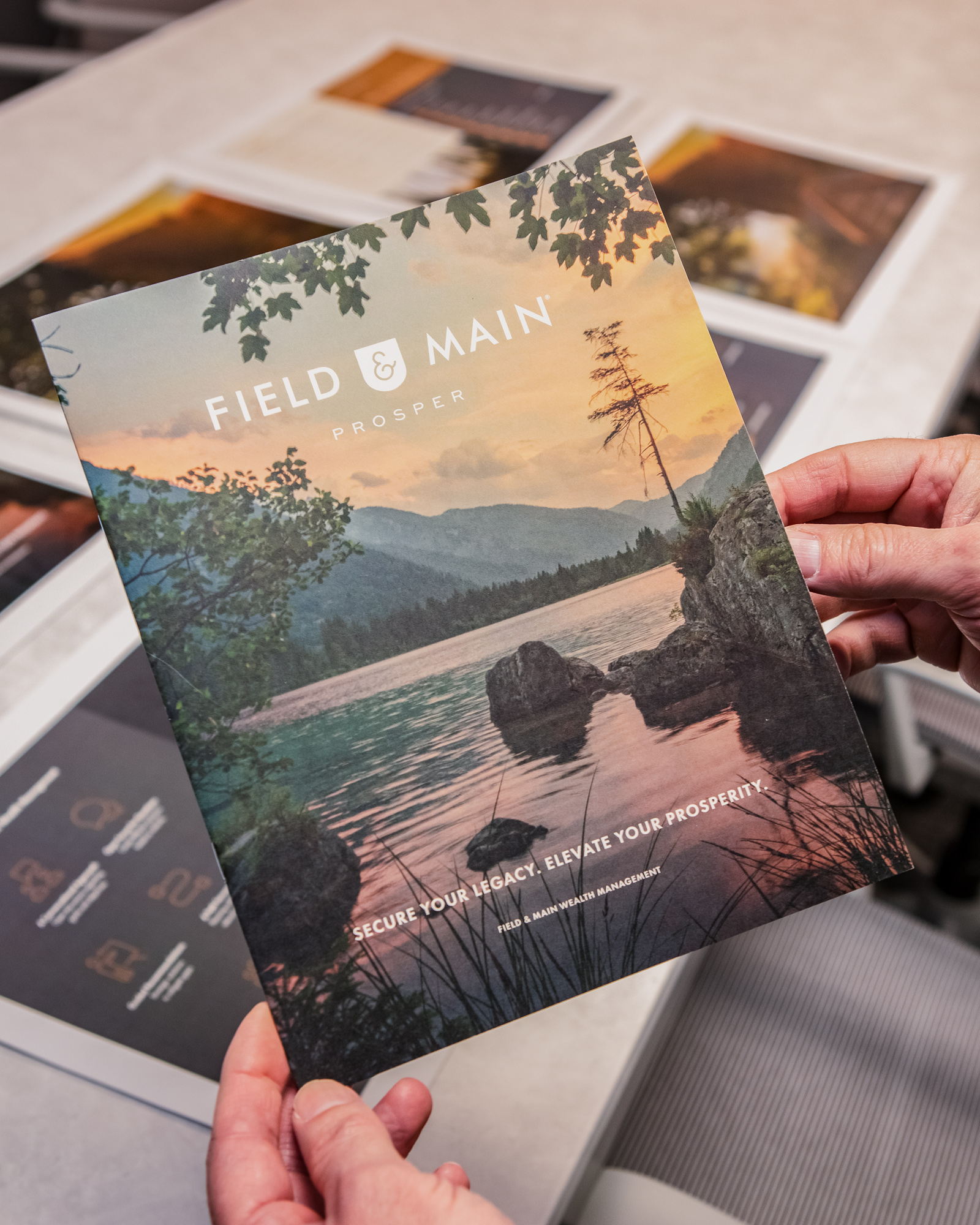 Hands holding Field and Main marketing collateral.