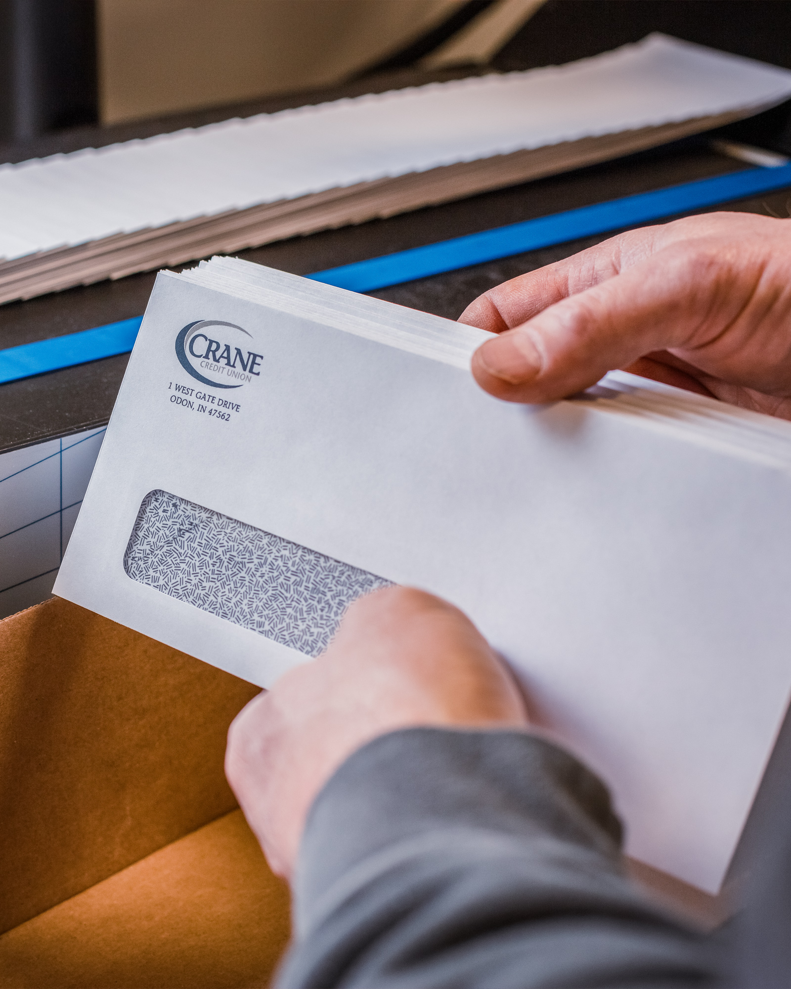 Close up of hands holding printed direct mail envelopes.