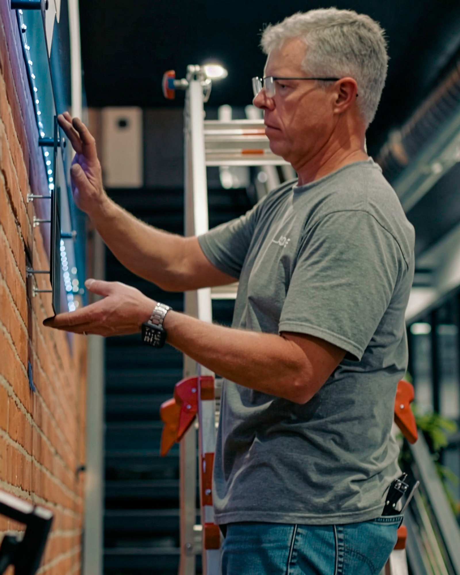 SLADE employee installing wall lettering.