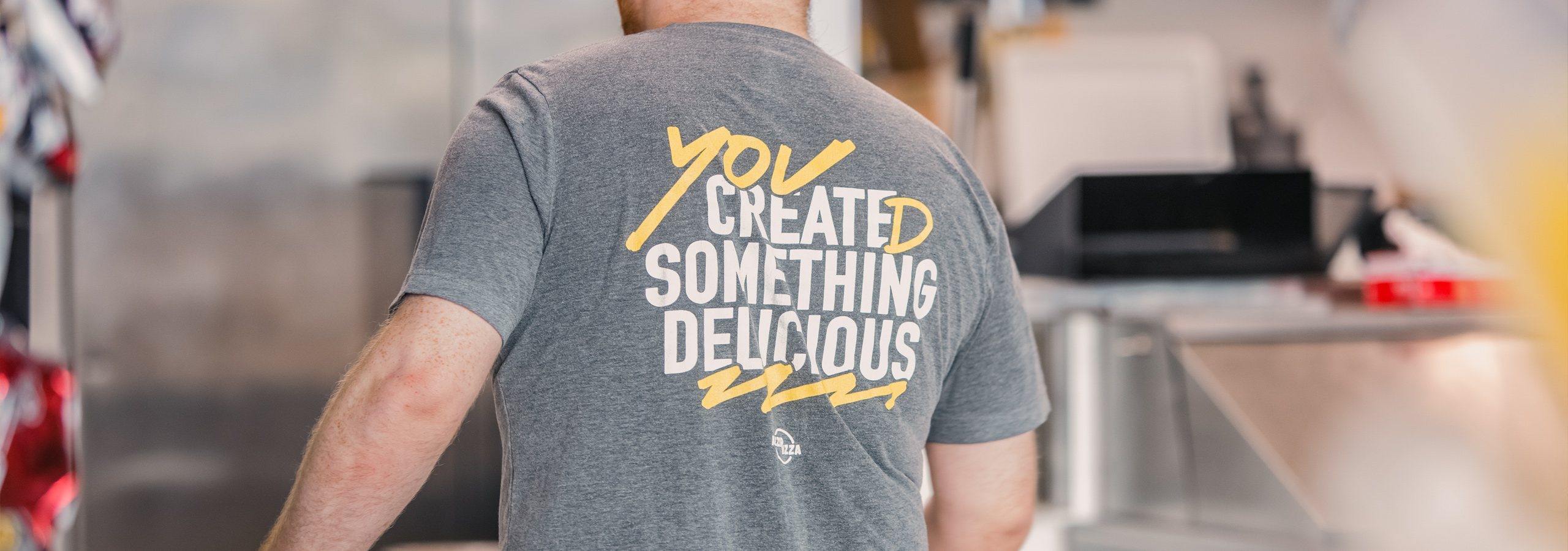 Back of Azzip Pizza employee T-shirt.