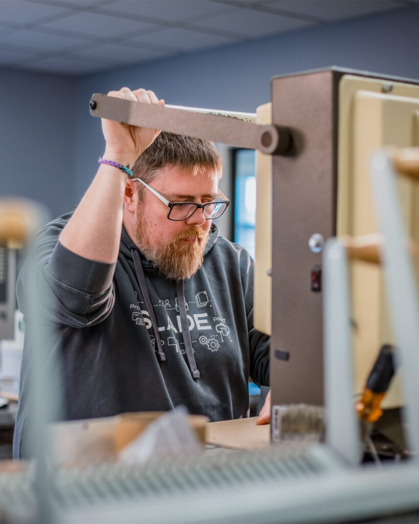 SLADE employee operating bindery cutter.