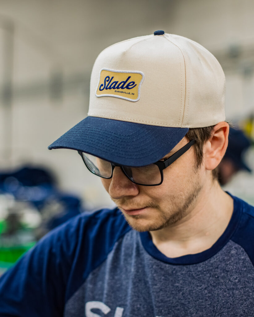 Man wearing SLADE logo patch on cap.