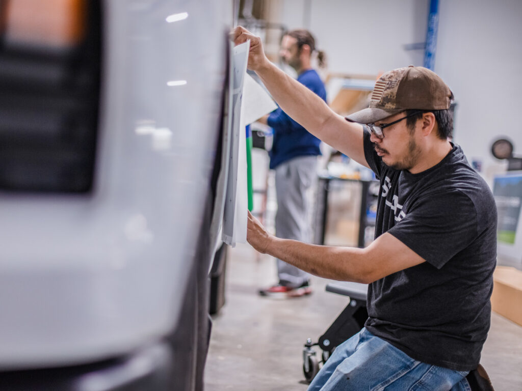 SLADE employee applying vehicle vinyl.