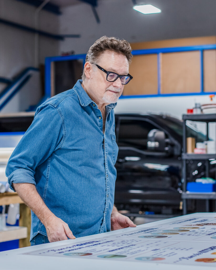 SLADE employee reviewing large format print.
