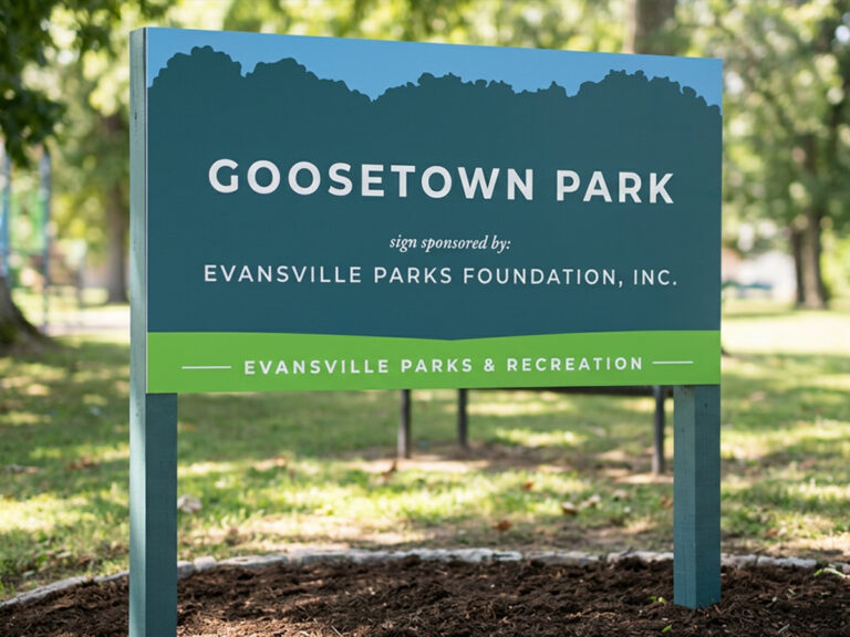 Goosetown Park sign mounted on two posts beside a park path.