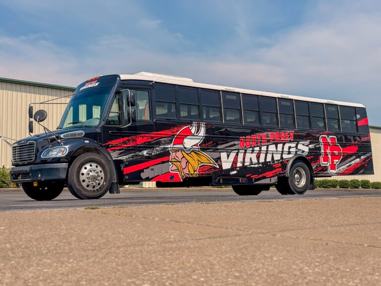 Bus wrapped in red and black North Posey Vikings graphics with a Viking mascot.