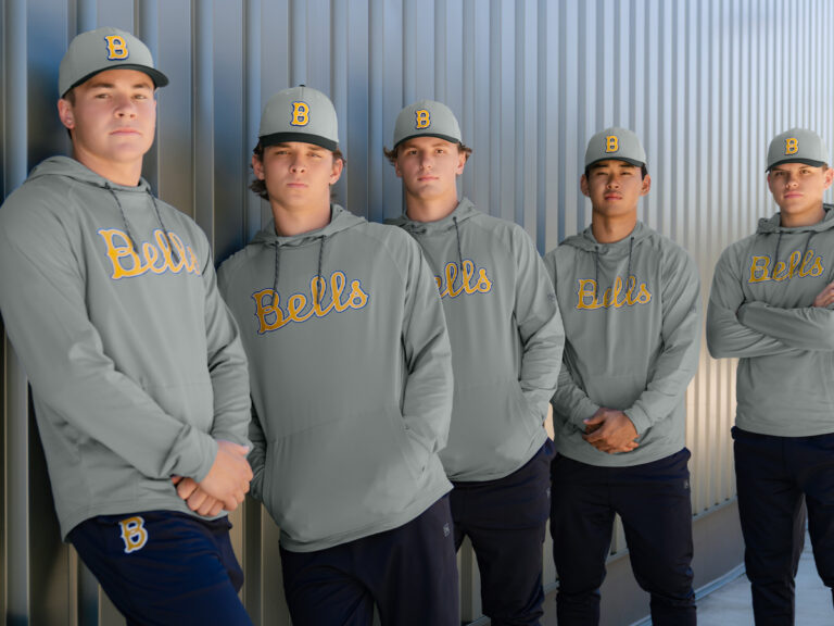 Five baseball players wearing matching gray Bells hoodies and caps.