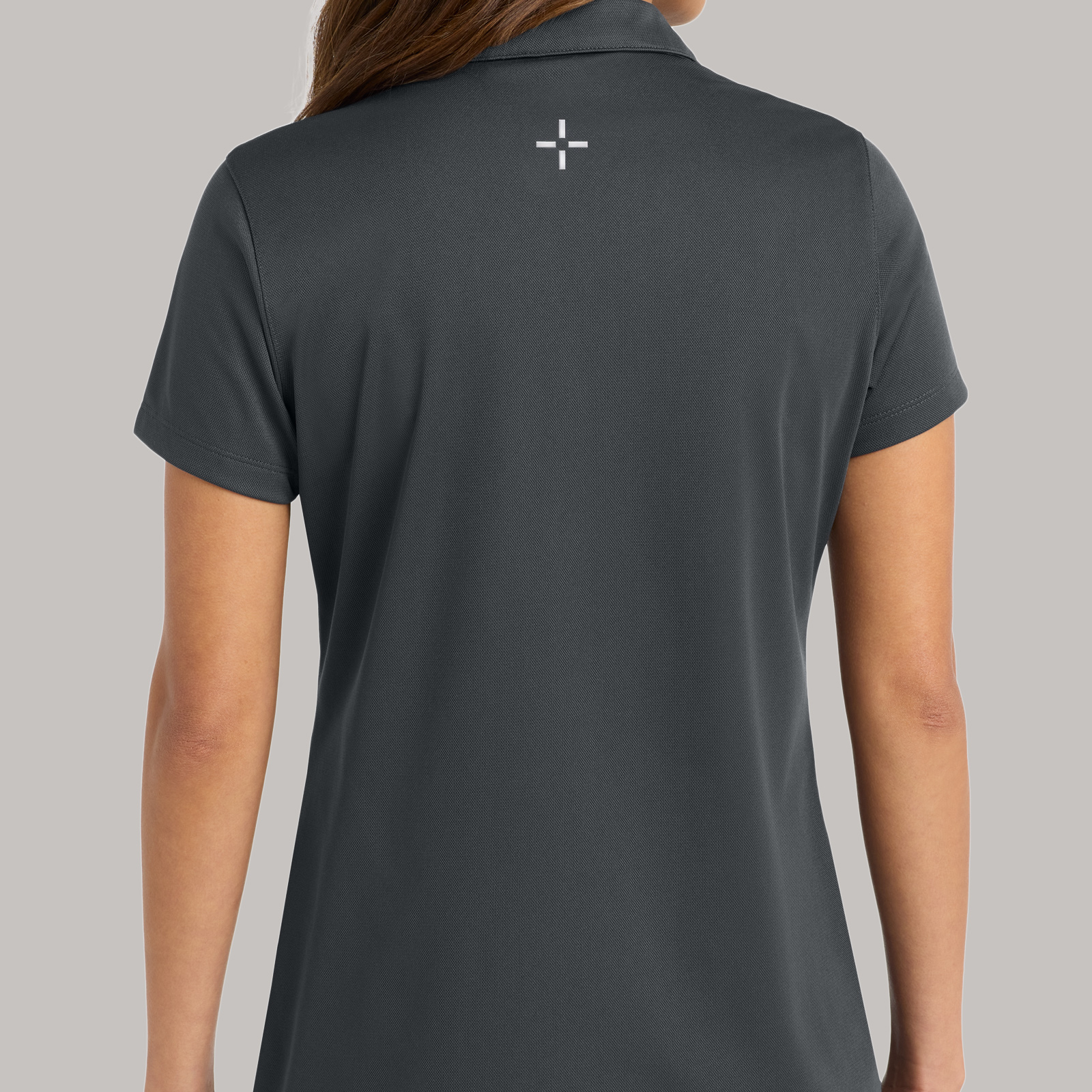 Back of a charcoal polo with a small geometric logo centered below the collar.