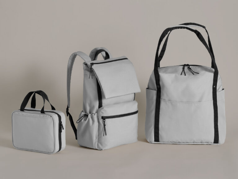 Gray lunch bag, backpack and tote with black straps and trim.