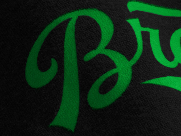 Green glow-in-the-dark lettering on black fabric.