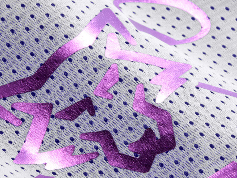 Shiny purple lettering and graphics on white mesh fabric.
