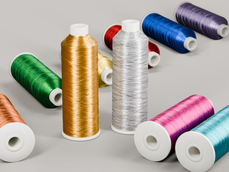 Spools of shiny embroidery thread in gold, silver and other colors.