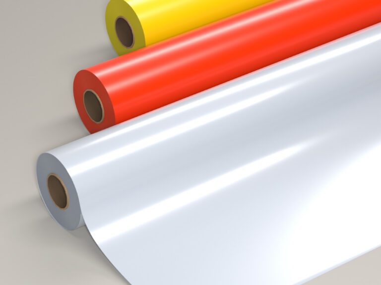 Glossy yellow, red and silver rolls of sign film, with the silver roll partly unrolled.
